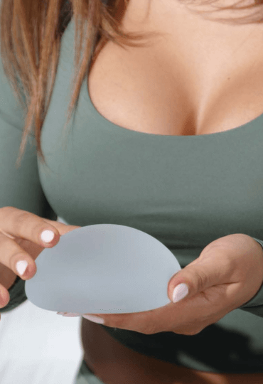 woman holding a breast implant